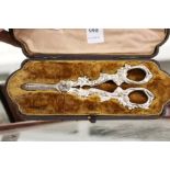 A cased set of ornate grape scissors.