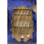 An unusual Dutch oak rack containing eight Dutch Delft porcelain handled knives.