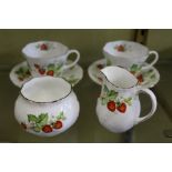 A pair of cups and saucers with cream jug and sugar bowl, decorated with strawberries.