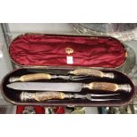 A cased horn handled carving set.