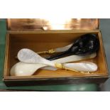 A copper cigarette box and decorative spoons.