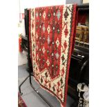 A small Kilim flat weave rug, red ground with stylized decoration.