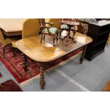 An oak extending dining table on barley twist legs.