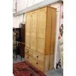 A large Victorian and later pine three door cupboard, the base with four drawers.