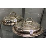 A pair of plated oval entree dishes and covers.