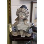 A Lladro bust of a clown playing an accordion.