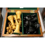 A box containing a quantity of ebony and box wood chess pieces.