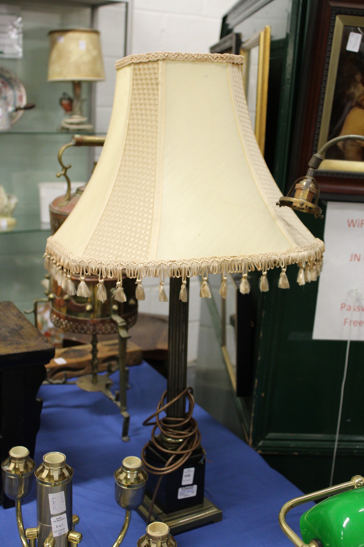 A Corinthian column style table lamp with shade.