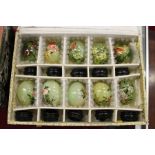 A boxed set of ten Chinese painted jade eggs on stands.