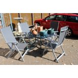 A garden table and four folding chairs.