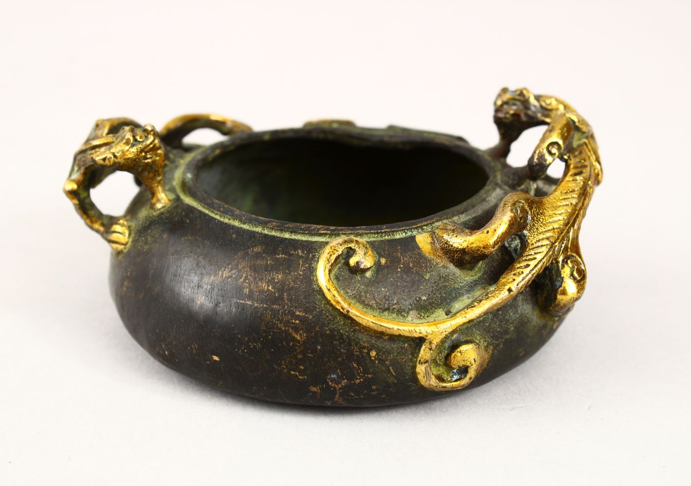 A 20TH CENTURY CHINESE BRONZE TWIN HANDLE CENSER, the censer with moulded gilded handles in the form
