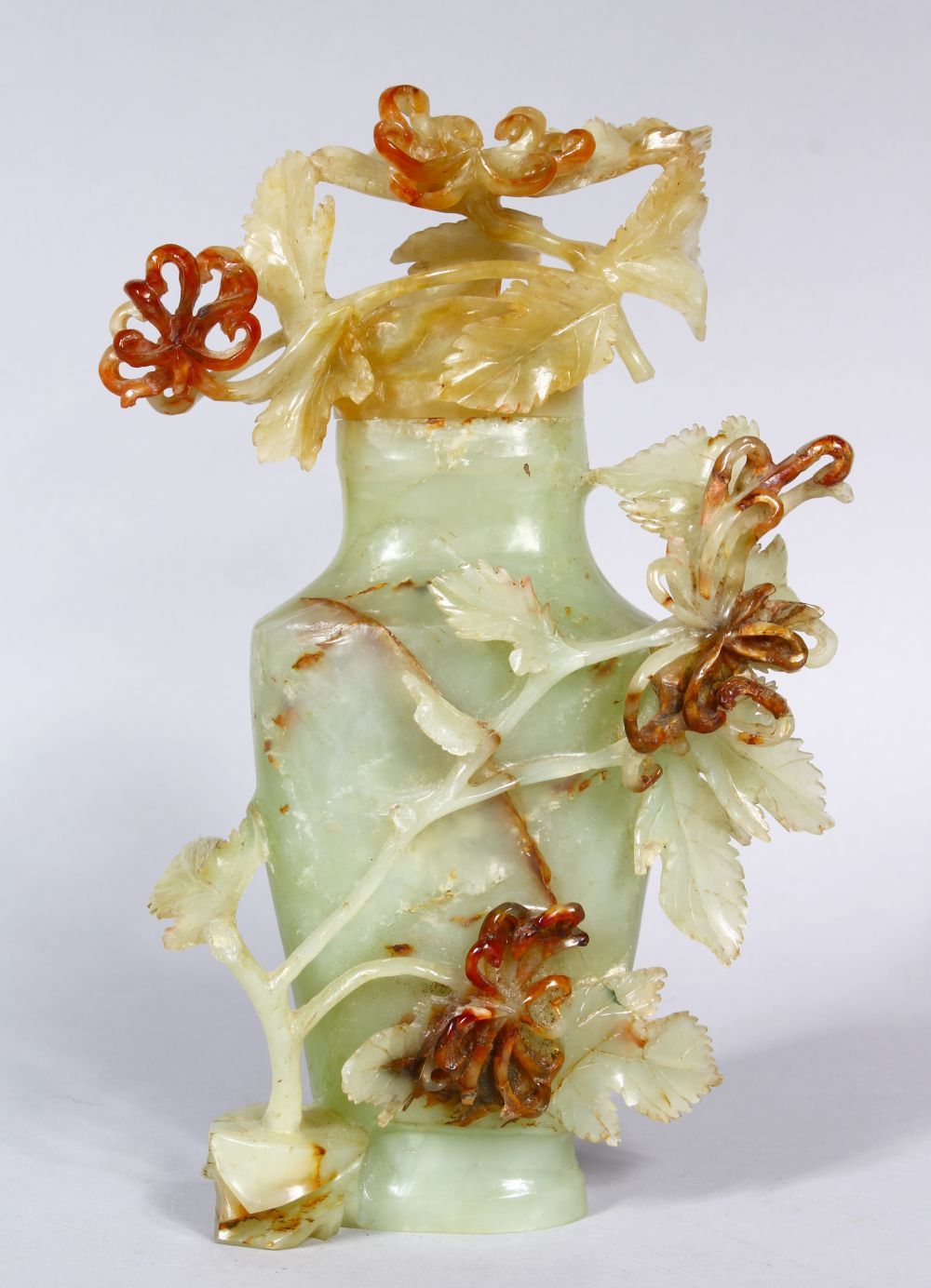 A GOOD 19TH CENTURY CHINESE CARVED JADE VASE AND COVER, the vase with carved detailed flora and