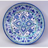 A PERSIAN OR CENTRAL ASIAN POTTERY CIRCULAR DISH, painted with stylised decoration, Iznik style,