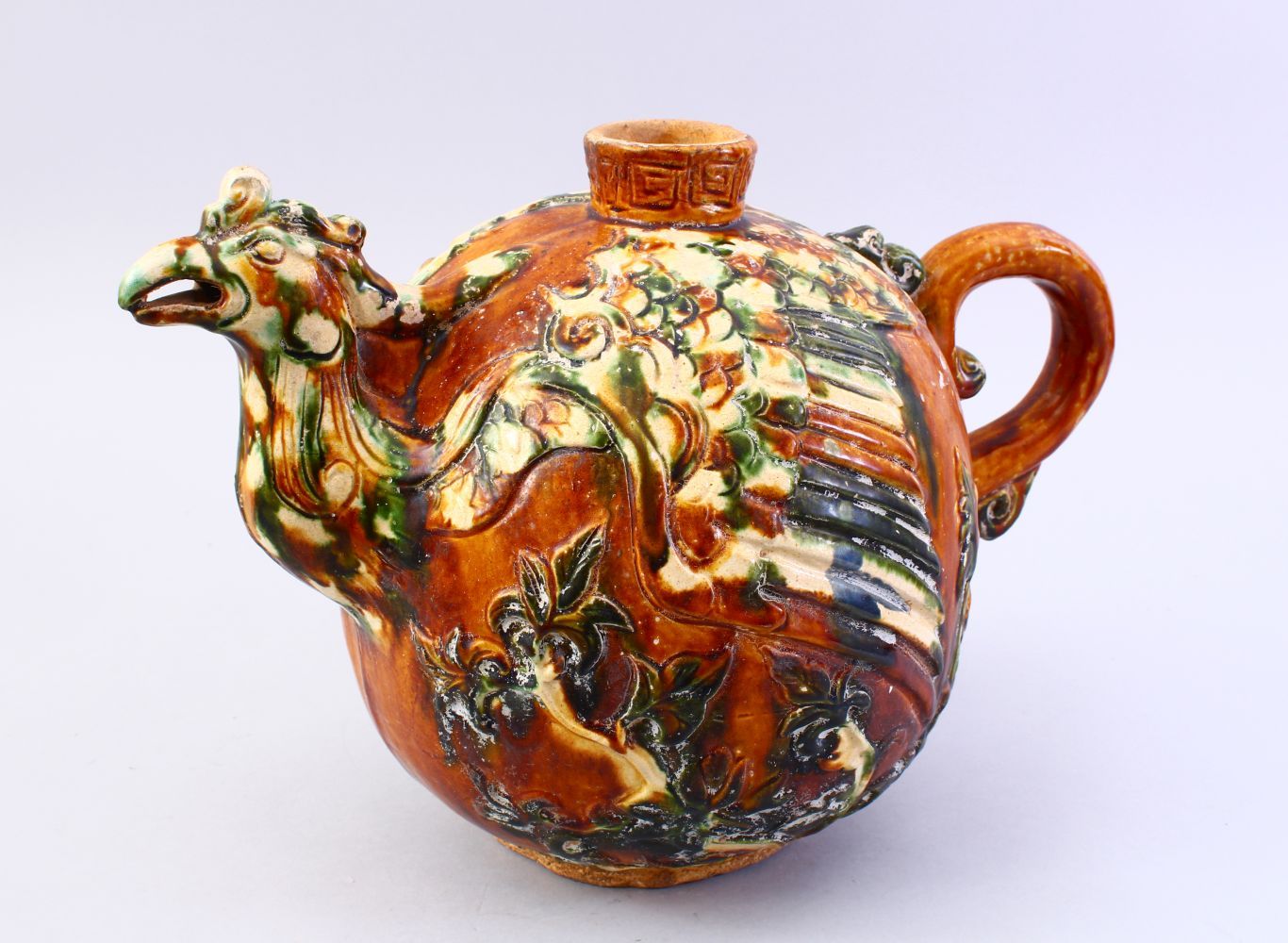 A LARGE CHINESE SANCAI GLAZED TANG STYLE POTTERY EWER, with carved and moulded decoration of a