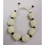 A SET OF CHINESE CARVED CELADON JADE BEAD BRACELET, the beads carved in the form of buddhas faces