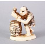 A JAPANESE MEIJI PERIOD CARVED AND STAINED IVORY OKIMONO - BARREL MAKER, the figure carved to depict