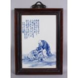 A GOOD CHINESE BLUE & WHITE PORCELAIN FRAMED TILE OF LUOHAN AND CHILDREN, in a landscape setting,