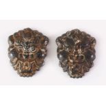 TWO TIBETAN CARVED HARDSTONE PENDANTS OF MYTHICAL MASKS, 8cm high.