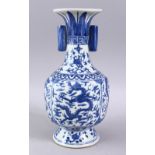 A CHINESE BLUE & WHITE PORCELAIN MING STYLE VASE, decorated with dragons amongst clouds, with twin