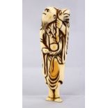 A LARGE JAPANESE EDO PERIOD CARVED IVORY NETSUKE OF A SENNIN, stood looking aloft holding a sack