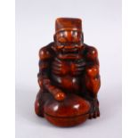 A GOOD JAPANESE MEIJI PERIOD CARVED WOODEN OKIMONO OF AN ONI BEATING A MOKUGYO, in a seated position