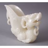 A 29TH CENTURY CHINESE CARVED WHITE JADE LIBATION CUP OF A LION DOG, 14cm high.