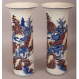 A PAIR OF CHINESE COPPER-RED & UNDERGLAZE-BLUE CYLINDRICAL PORCELAIN VASES, each decorated with a