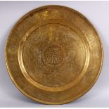 A GOOD CHINESE CARVED BRASS SYMBOLIC DISH, decorated with dragons and symbols / calligraphy, 46cm.