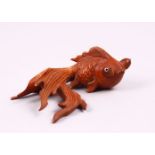 A CHINESE CARVED BOXWOOD/ WOODEN FIGURE OF A GOLDFISH, with glass inset eyes, 3cm x 8cm.