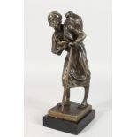 A BRONZE FIGURE OF AN ARAB MAN WITH A STICK, carrying a water bottle on his back. 9.5ins high.