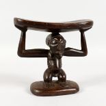 A LUBA CARVED WOOD HEADREST. 6ins high.