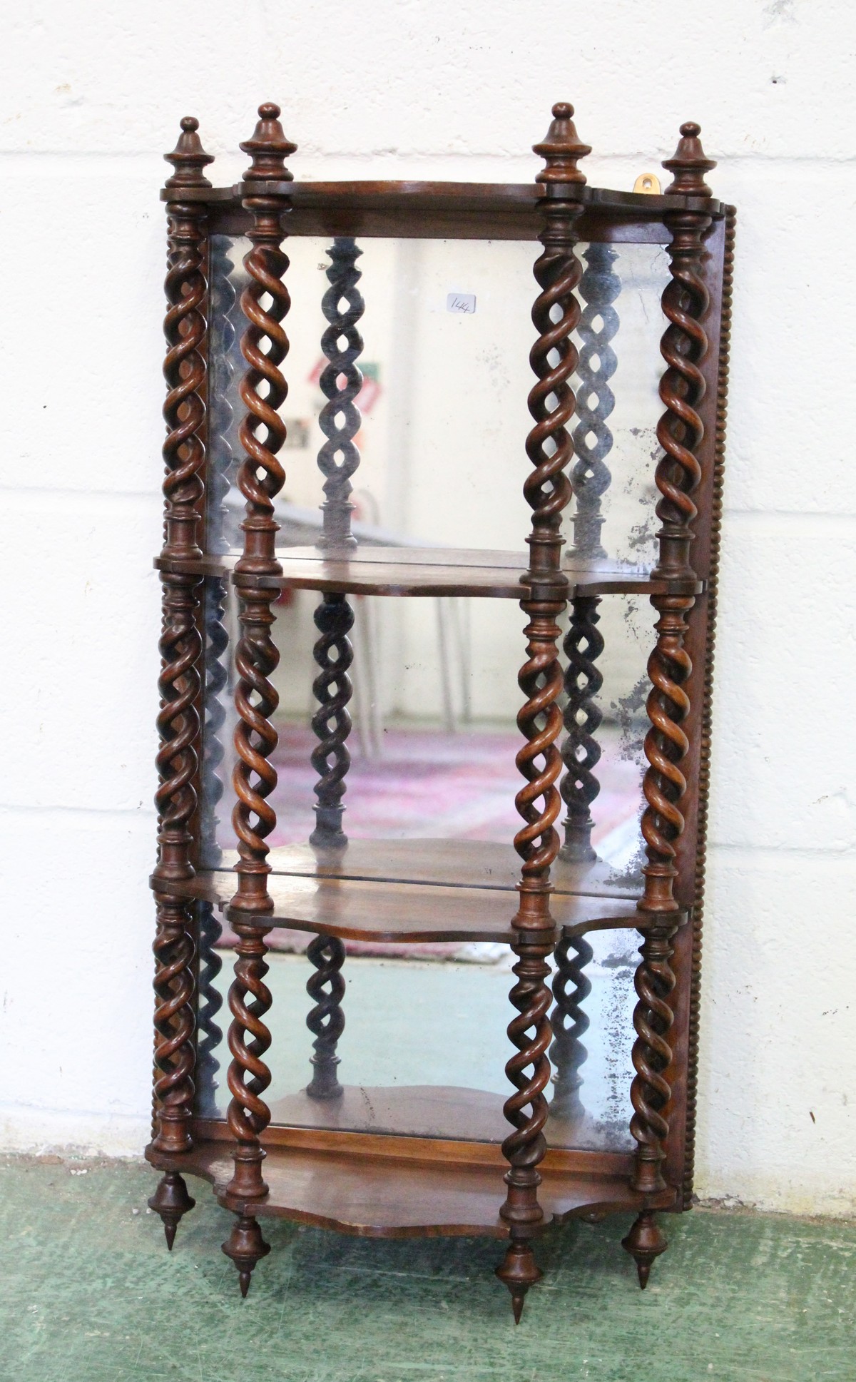 A GOOD 19TH CENTURY ROSEWOOD WALL SHELF, with a mirrored back, the shelves united by open barley