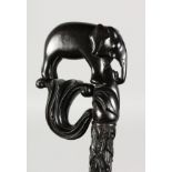 A CEYLONESE CARVED WALKING STICK with elephant handle. 35ins long.