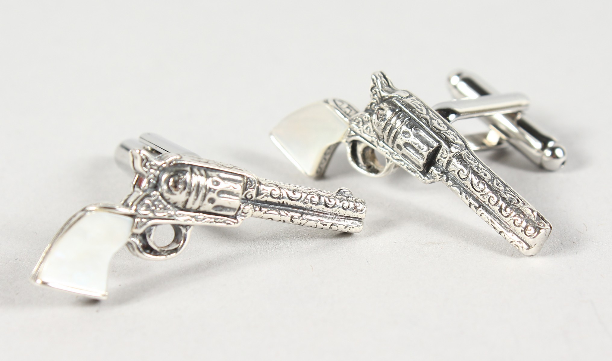 A PAIR OF SILVER AND MOTHER-OF-PEARL PISTOL CUFFLINKS.