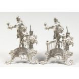 TWO PIERCED AND EMBOSSED SILVER FIGURAL STANDS. 3.5ins high.