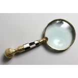 A LADIES MAGNIFYING GLASS with chequered and brass handle.