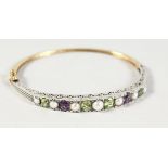 A GOOD 9CT GOLD AND SILVER, PERIDOT, PEARL AND AMETHYST BANGLE.