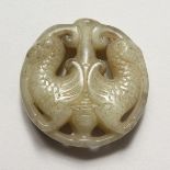 A CHINESE CARVED JADE ROUNDEL. 1.75ins diameter.