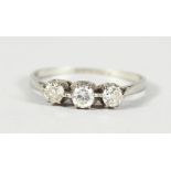 AN 18CT GOLD THREE STONE DIAMOND RING.