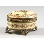 A SMALL PORCELAIN DECORATED OVAL JEWELLERY BOX. TAHAN LABEL, PARIS. 3ins long.