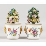 A PAIR OF DRESDEN FLOWER POTS, with encrusted flowers, the pots with gilt masks. 5.5ins high.