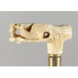 A WALKING STICK, the bone handle carved as a bird on a branch. 34ins long.