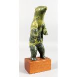 AN INUIT COLOURED STONE CARVING OF A BEAR, standing on its back legs, on a wooden base. 9ins high.