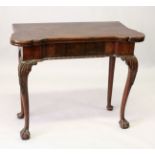 A GEORGE III MAHOGANY CARD TABLE, the fold-over top of shaped outline with four counter wells, green