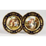 A GOOD PAIR OF 19TH CENTURY VIENNA PLATES, rich blue and gilt borders, painted with classical
