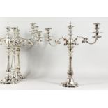A VERY GOOD SET OF FOUR SHEFFIELD PLATE TWO-BRANCH CANDELABRA, with scrolling branches. 18.5ins