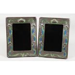A PAIR OF ART NOUVEAU STYLE SILVER AND ENAMEL PHOTOGRAPH FRAMES. 7.5ins x 5.75ins.
