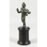 AN ANTIQUE BRONZE PUTTI on a stand.