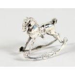 A MINIATURE SILVER ROCKING HORSE.