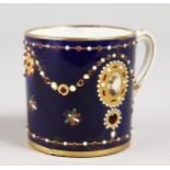 A SMALL 19TH CENTURY SEVRES MUG, jewelled on a cobalt blue ground.